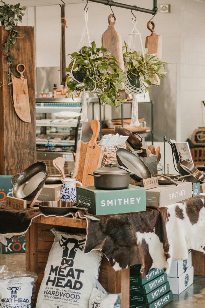 A curated selection of kitchen tools and decor in a rustic butcher shop setting.